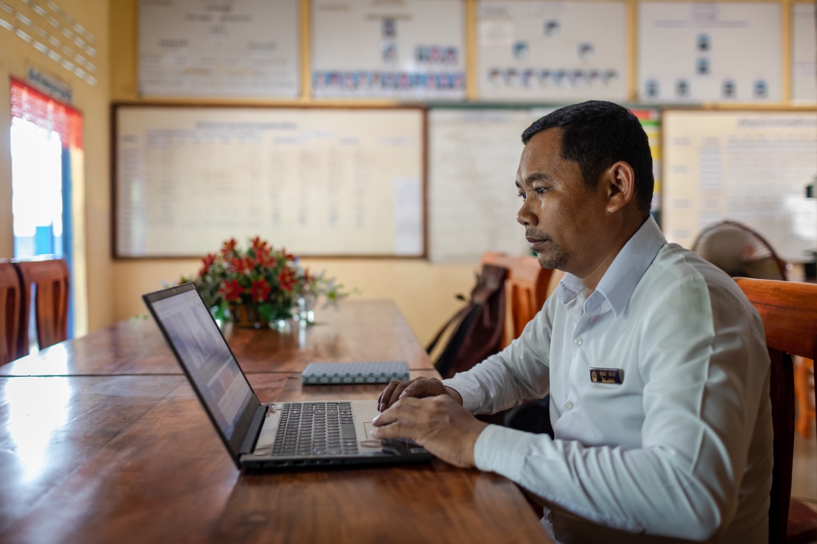 El Ang, principal of Chambak Haer Primary School, Puok District, checks in on student progress through a dedicated app while working in his office in Siem Reap, Cambodia. Credit: GPE/Roun Ry
