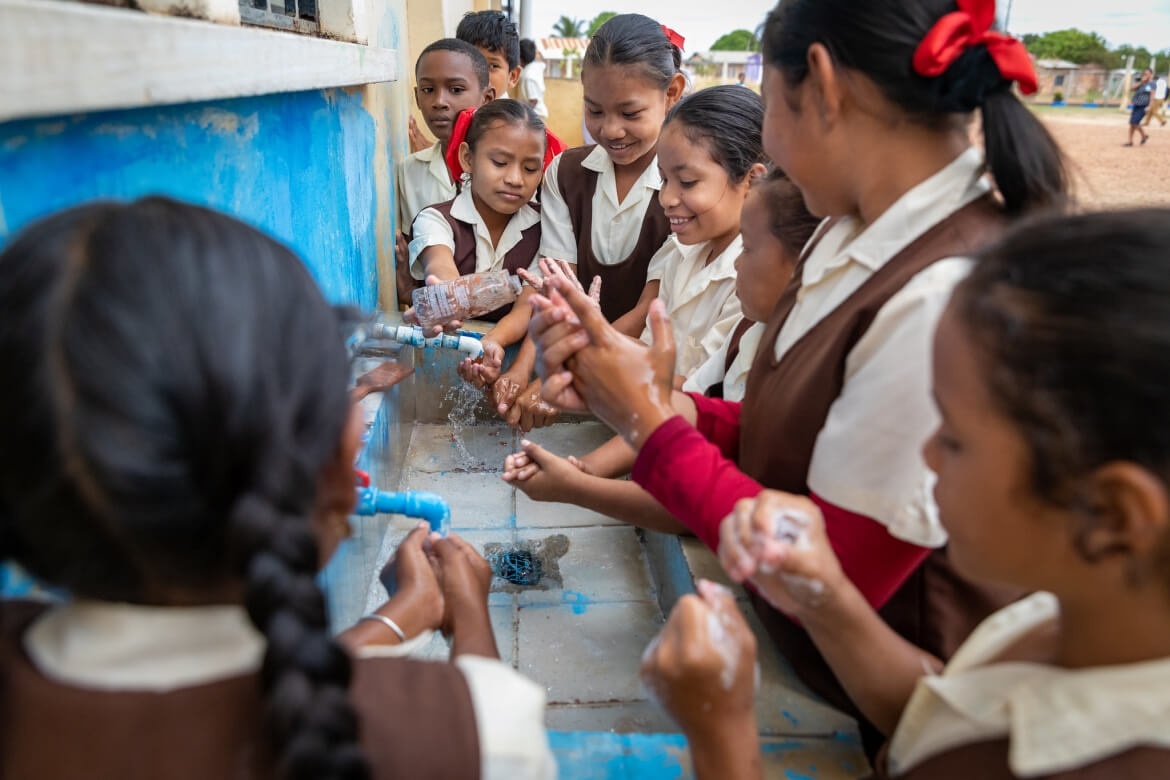 Students at Saint Ignatius Primary School wash their hands after an art project. Lethem, Region 9, Guyana