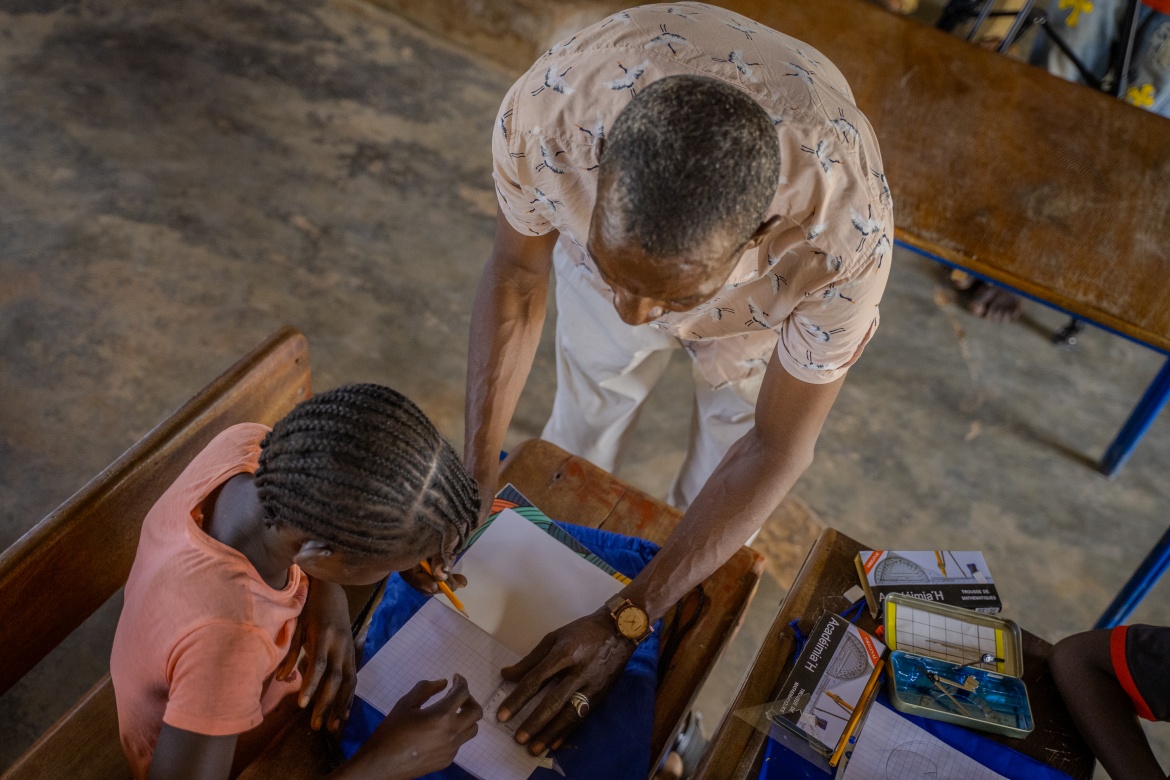 A teacher shows a student how to use the supplies included in the school kit delivered to conflict-affected areas like Banamba, Mali. Credit: GPE/Infinitee!